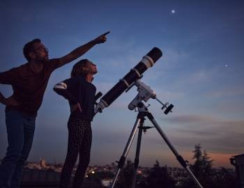 Family looking at stars through telescope